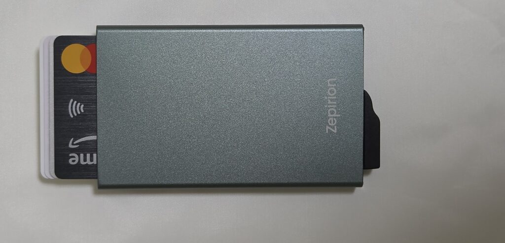Zepirion Quick Wallet Pocketの側面にあるスライドボタンを押し、カードが一部飛び出した状態。手前にMastercardのロゴが見える
